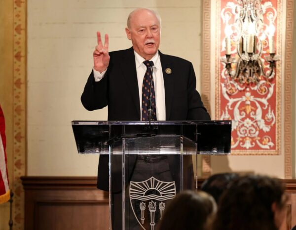 Daniel J. Epstein speaking at a podium